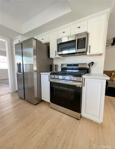 a kitchen with stainless steel appliances a stove a refrigerator sink and microwave