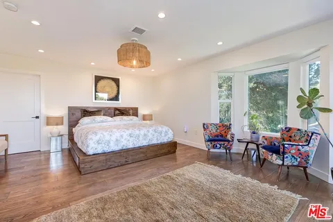 a bedroom with a bed and a large window