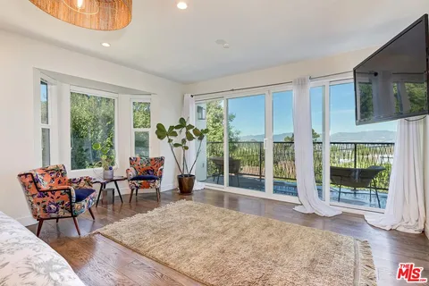 a living room with furniture and large windows