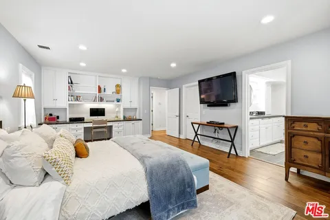 a bedroom with a bed and a flat screen tv