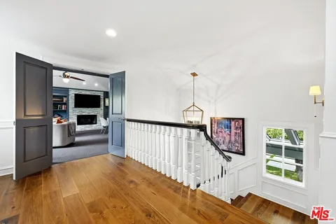 a view of a hallway with an empty room and wooden floor
