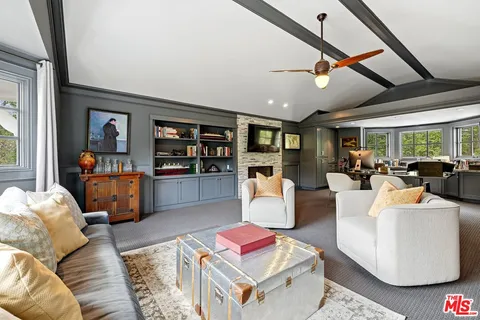 a living room with furniture kitchen view and a large window