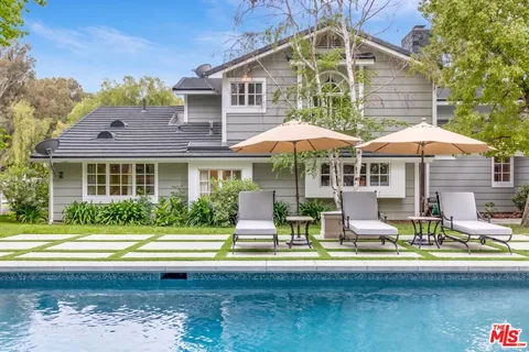 a front view of a house with swimming pool and porch