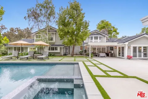 a house with swimming pool in front of it