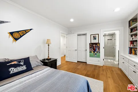 a spacious bedroom with a bed and a book shelf