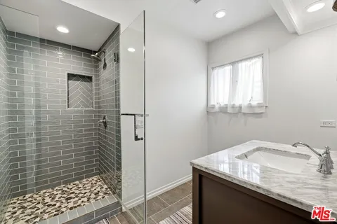 a bathroom with a granite countertop sink a toilet and shower