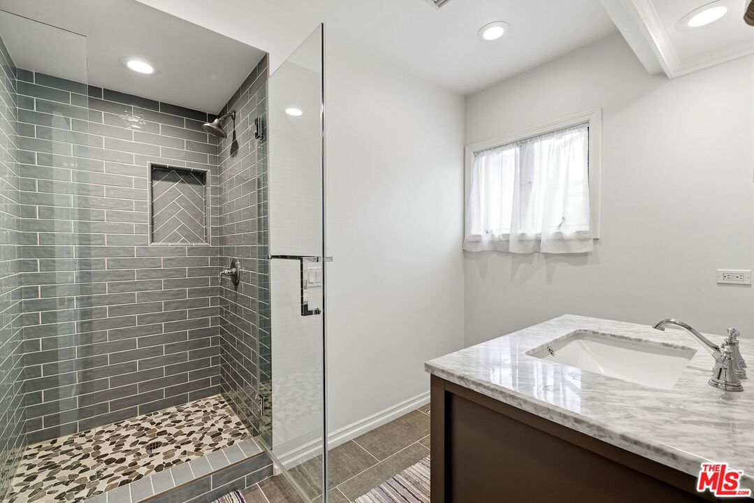 24317 Bridle Trail Road Hidden Hills, CA 91302 - Photo 33 of 37 a bathroom with a granite countertop sink a toilet and shower