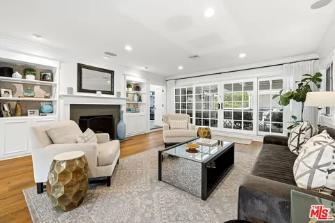 a living room with furniture fireplace and a large window