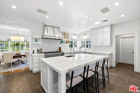 a kitchen with a stove a refrigerator and a dining table