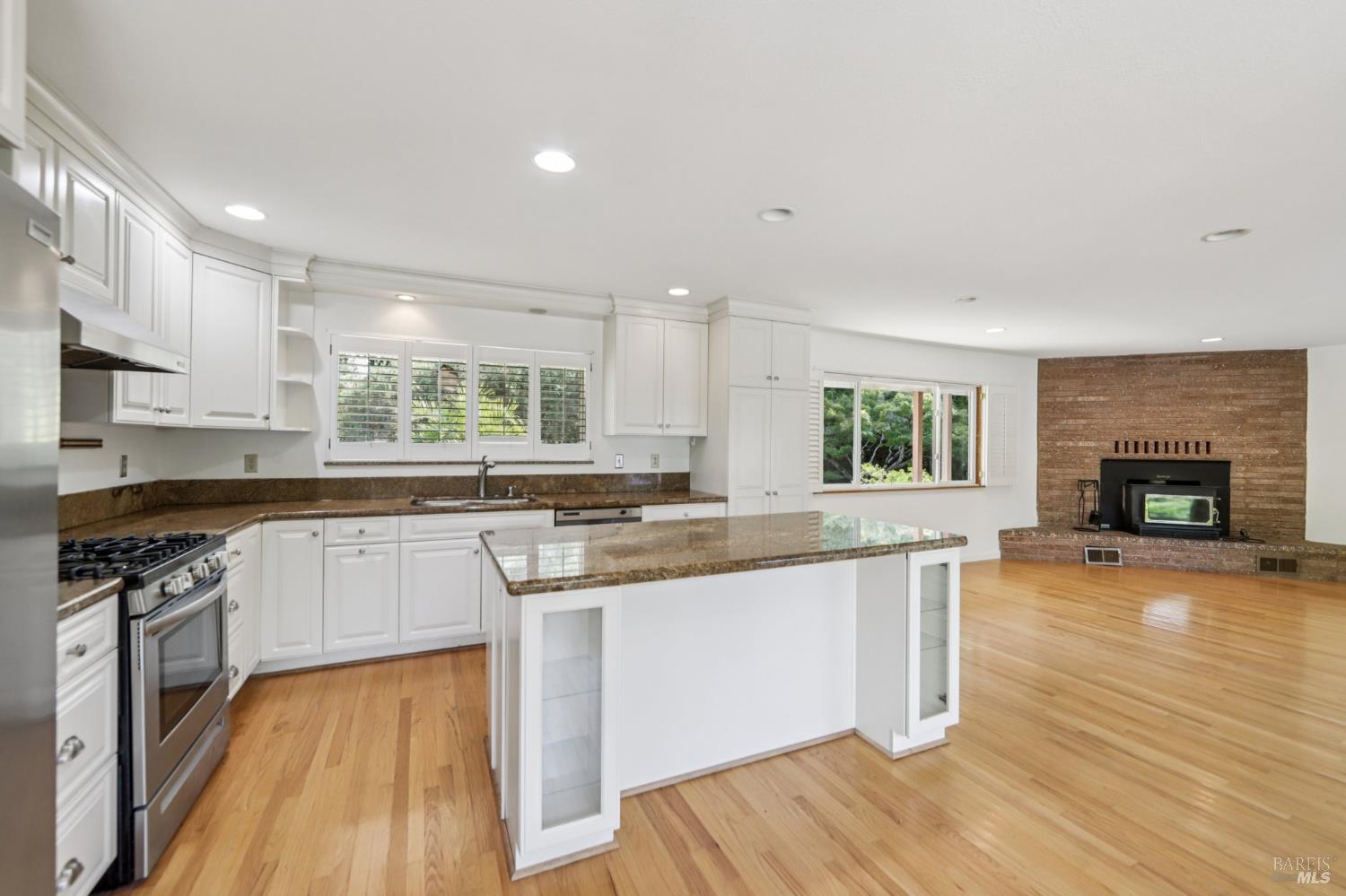 1050 Sunset Road Napa, CA 94558 - Photo 12 of 67 a kitchen with stainless steel appliances granite countertop wooden floor a stove a sink and a microwave