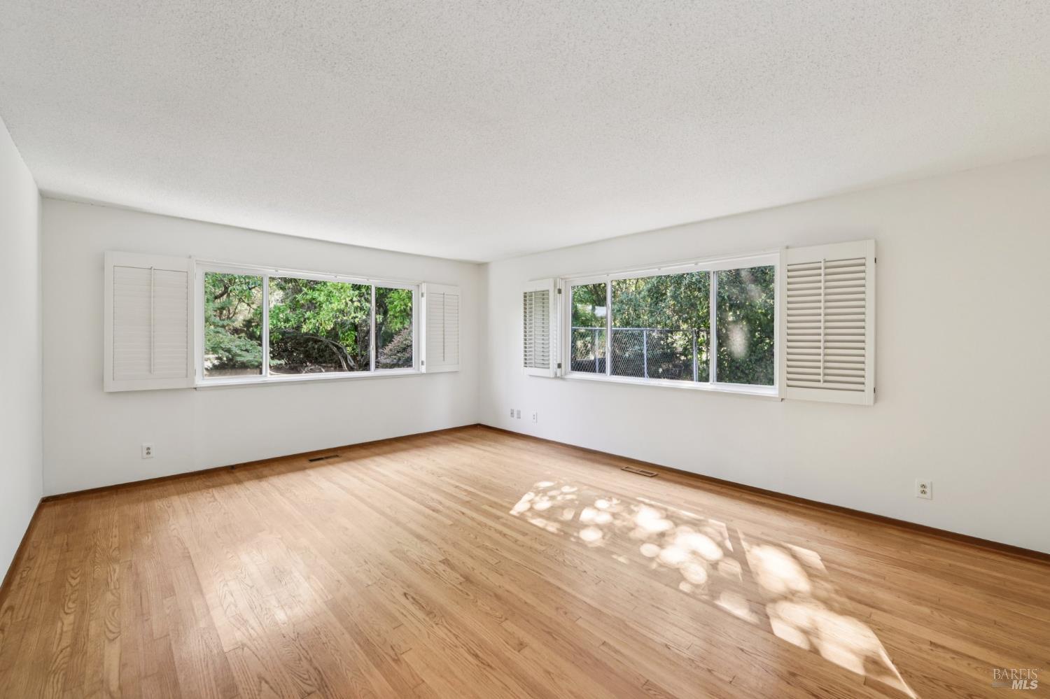 1050 Sunset Road Napa, CA 94558 - Photo 18 of 67 an empty room with wooden floor and windows