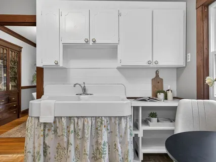 a kitchen with stainless steel appliances granite countertop a sink a stove and white cabinets