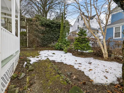 a view of a chair and table in backyard of the house