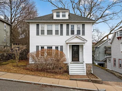 a front view of a house with a tree