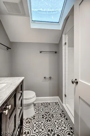 a bathroom with a granite countertop sink and a toilet