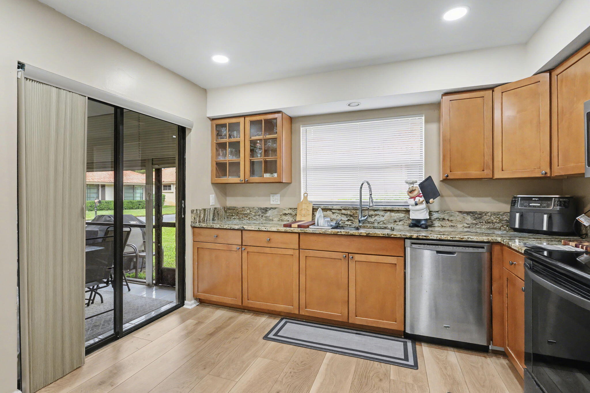 4635 Apple Tree Circle, Unit A Boynton Beach, FL 33436 - Photo 16 of 25 a kitchen with granite countertop cabinets stainless steel appliances a sink and a large window
