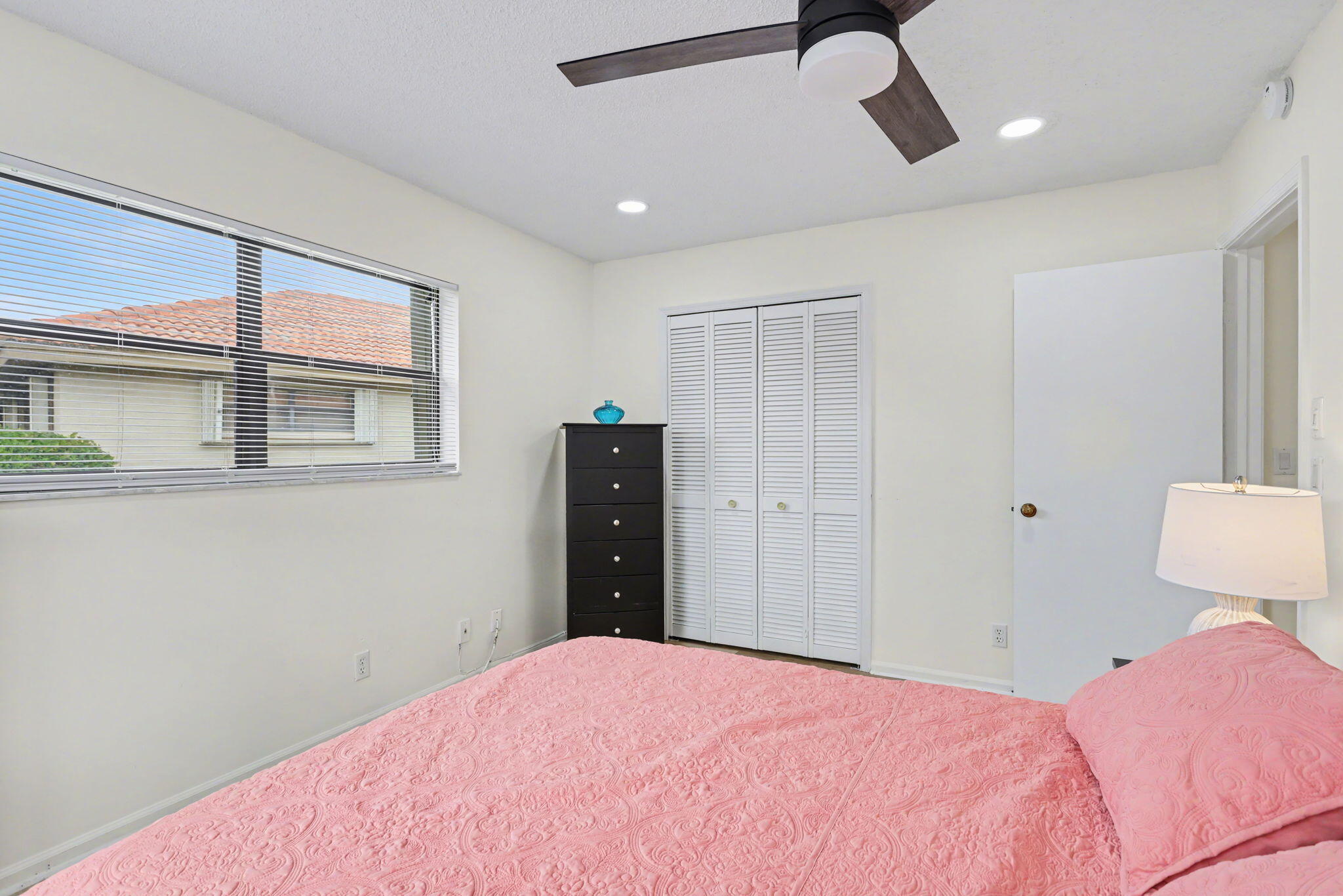 4635 Apple Tree Circle, Unit A Boynton Beach, FL 33436 - Photo 20 of 25 a bedroom with a bed and a chandelier