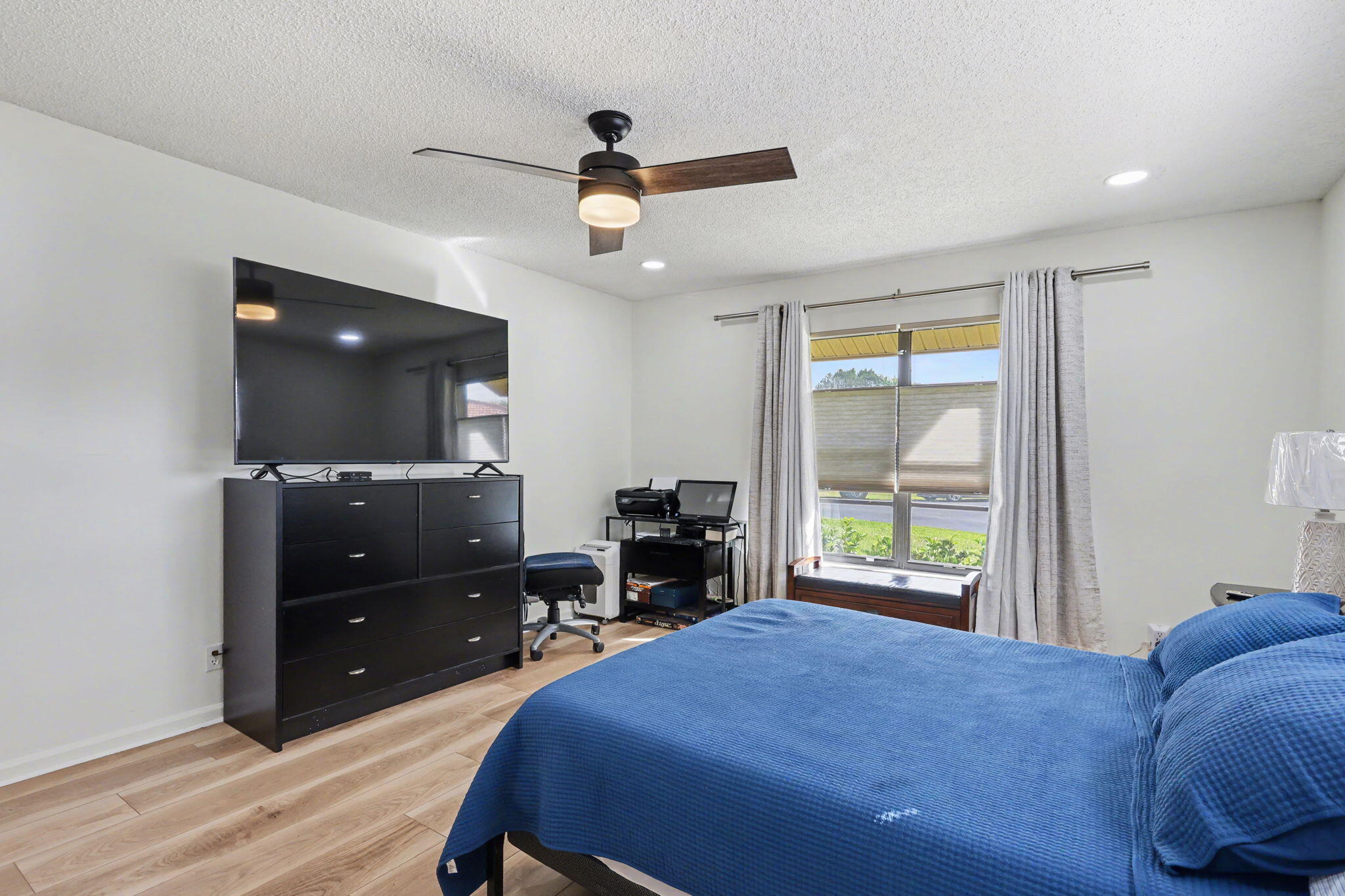 4635 Apple Tree Circle, Unit A Boynton Beach, FL 33436 - Photo 23 of 25 a bedroom with a bed and a flat tv screen on dresser