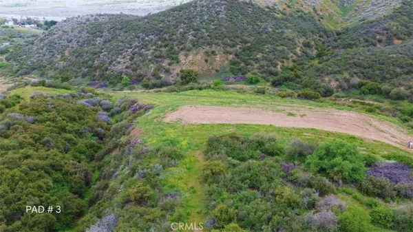 an aerial view of a house with a yard and mountain
