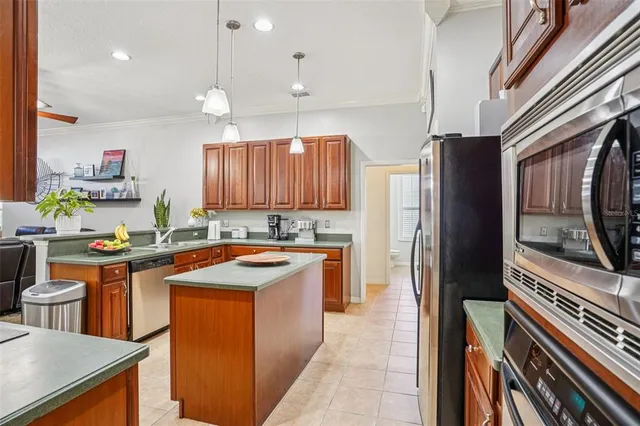 a kitchen with stainless steel appliances granite countertop a refrigerator a sink dishwasher a stove and white countertops with wooden floor