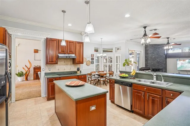 a kitchen with stainless steel appliances granite countertop a sink a stove and a wooden cabinets