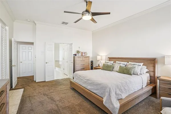 a bedroom with a large bed and a chandelier
