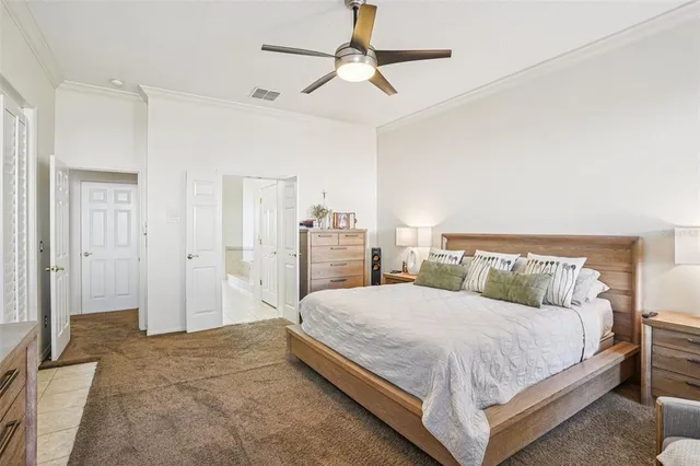 a bedroom with a large bed and a chandelier