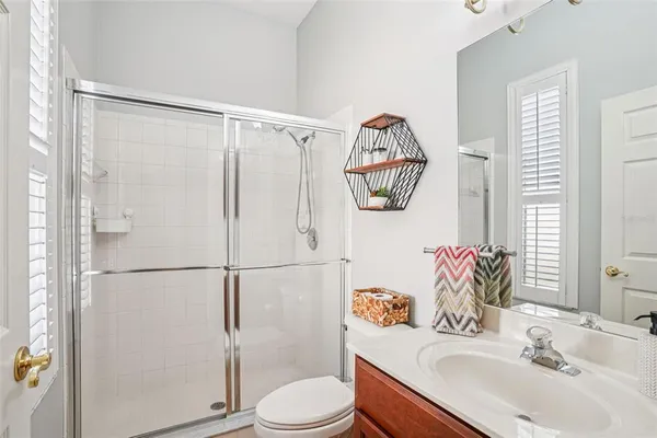 a bathroom with a sink vanity mirror and toilet