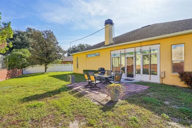 a view of a house with backyard and sitting area