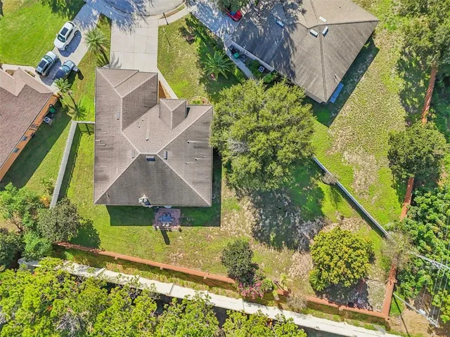 a view of a house with large trees and a yard