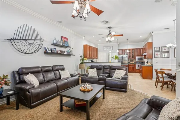 a living room with furniture kitchen view and a chandelier