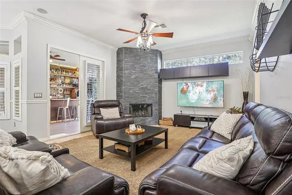 a living room with furniture a fireplace and a chandelier