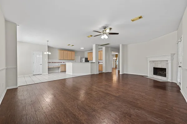 a view of empty room with wooden floor and fireplace