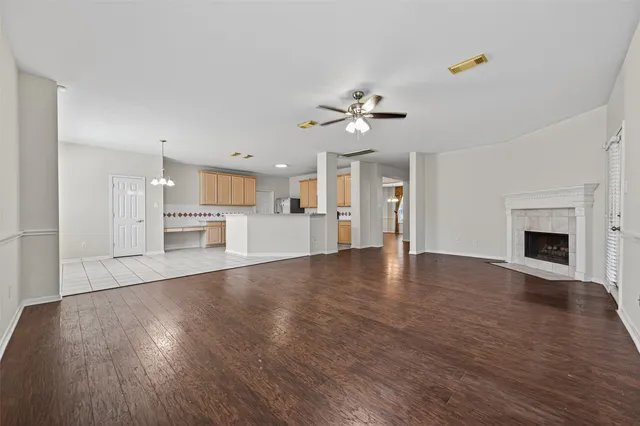 a view of empty room with wooden floor and fireplace