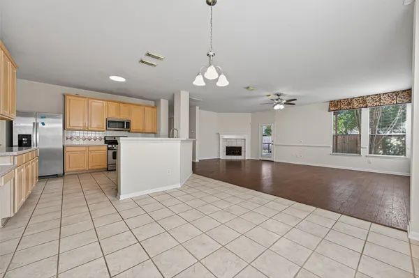 a kitchen with stainless steel appliances granite countertop a refrigerator a oven and a sink with granite countertops
