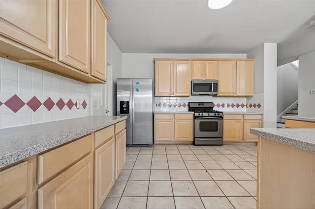 a kitchen with granite countertop a sink stove top oven and cabinets