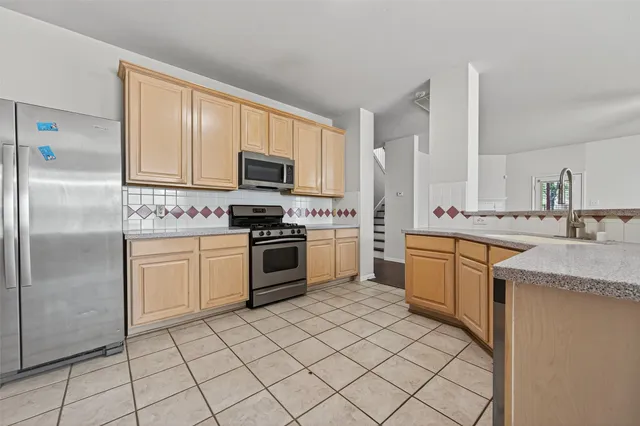 a kitchen with a sink appliances and cabinets