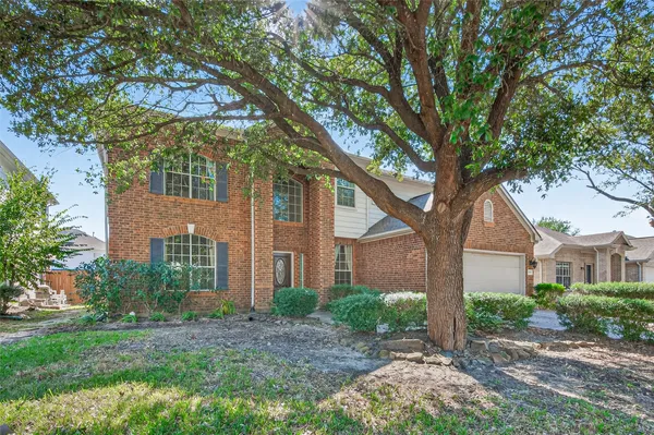 a view of a brick house next to a large trees