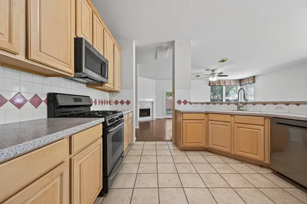 a kitchen with stainless steel appliances granite countertop a sink and dishwasher a stove top oven with white cabinets