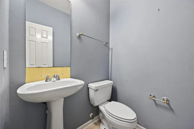 a bathroom with a sink a toilet and mirror