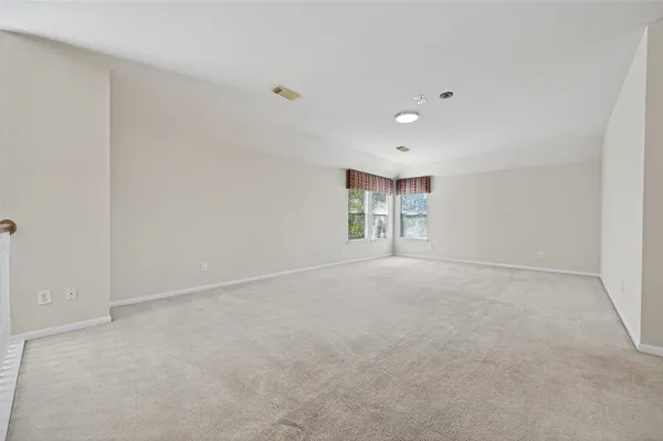 a view of a big room with windows and chandelier fan