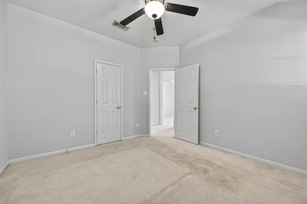 an empty room with chandelier fan