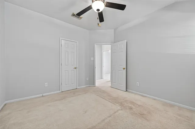 an empty room with chandelier fan