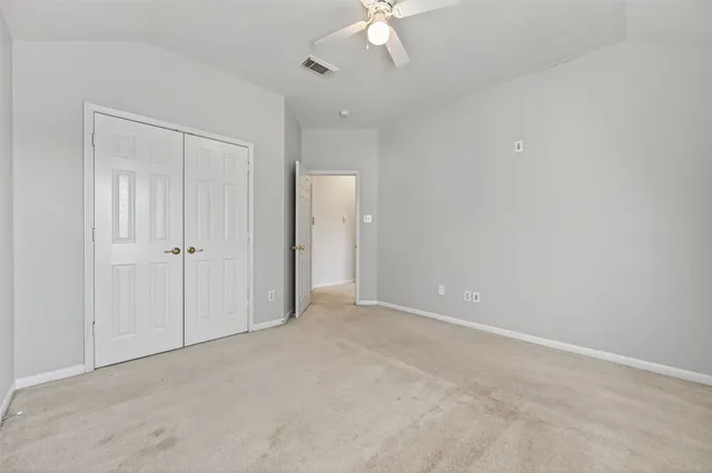 an empty room with a ceiling fan and a window