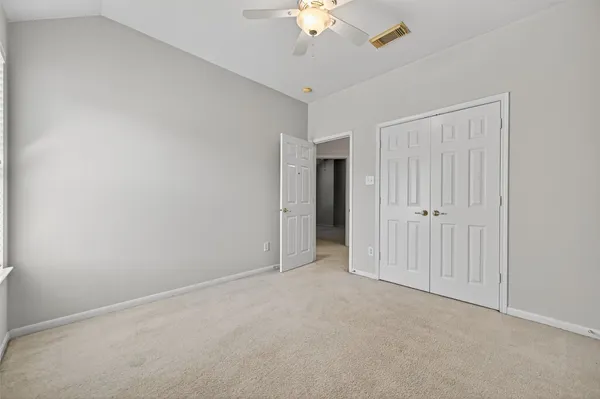 an empty room with a ceiling fan and a window