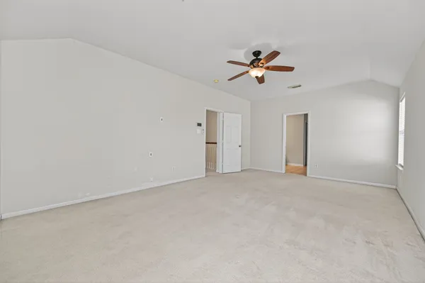 an empty room with closet and a ceiling fan