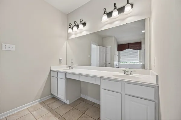 a bathroom with a double vanity sink mirror and