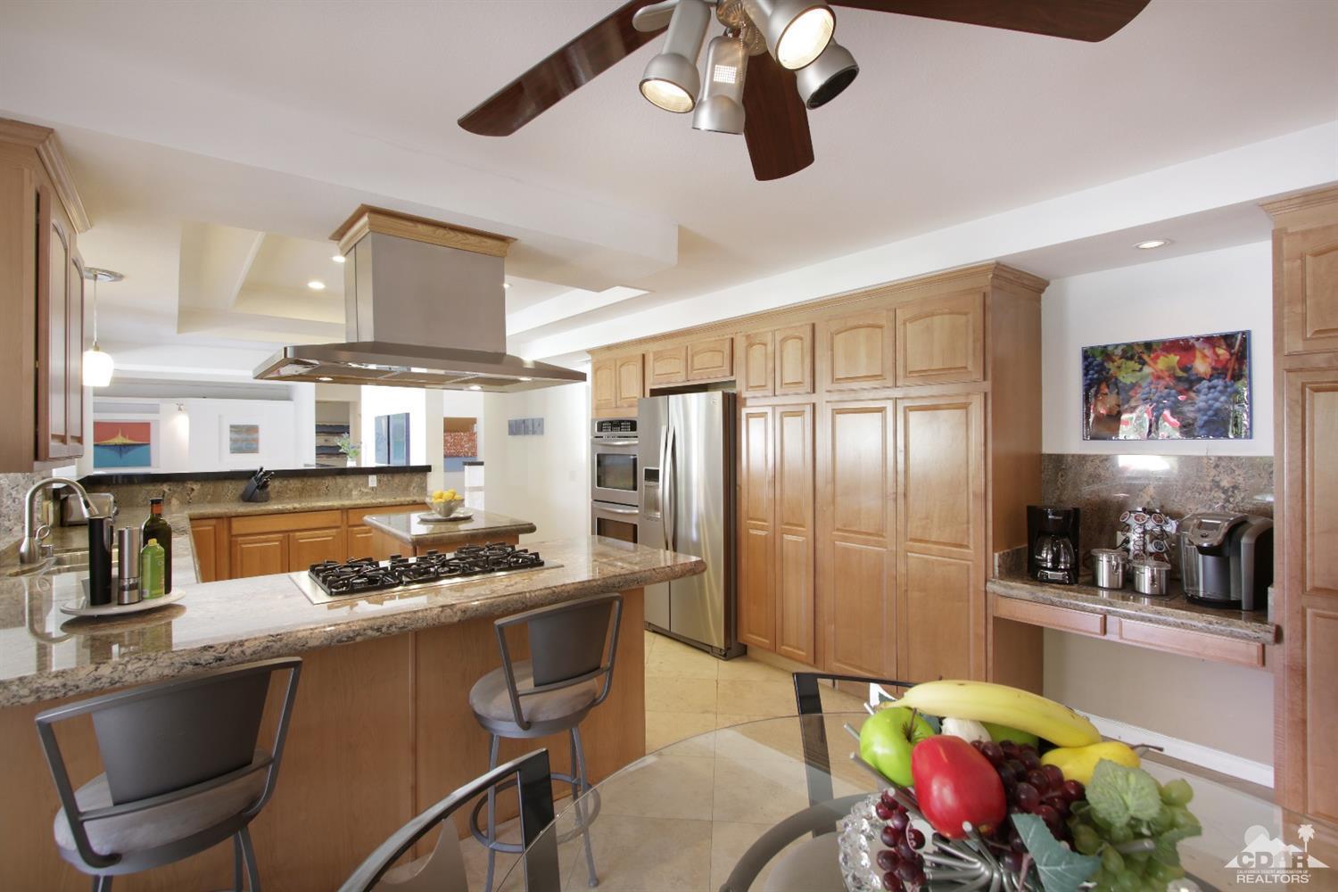 75570 Fairway Drive Indian Wells, CA 92210 - Photo 12 of 38 a kitchen with stainless steel appliances granite countertop a stove refrigerator and cabinets