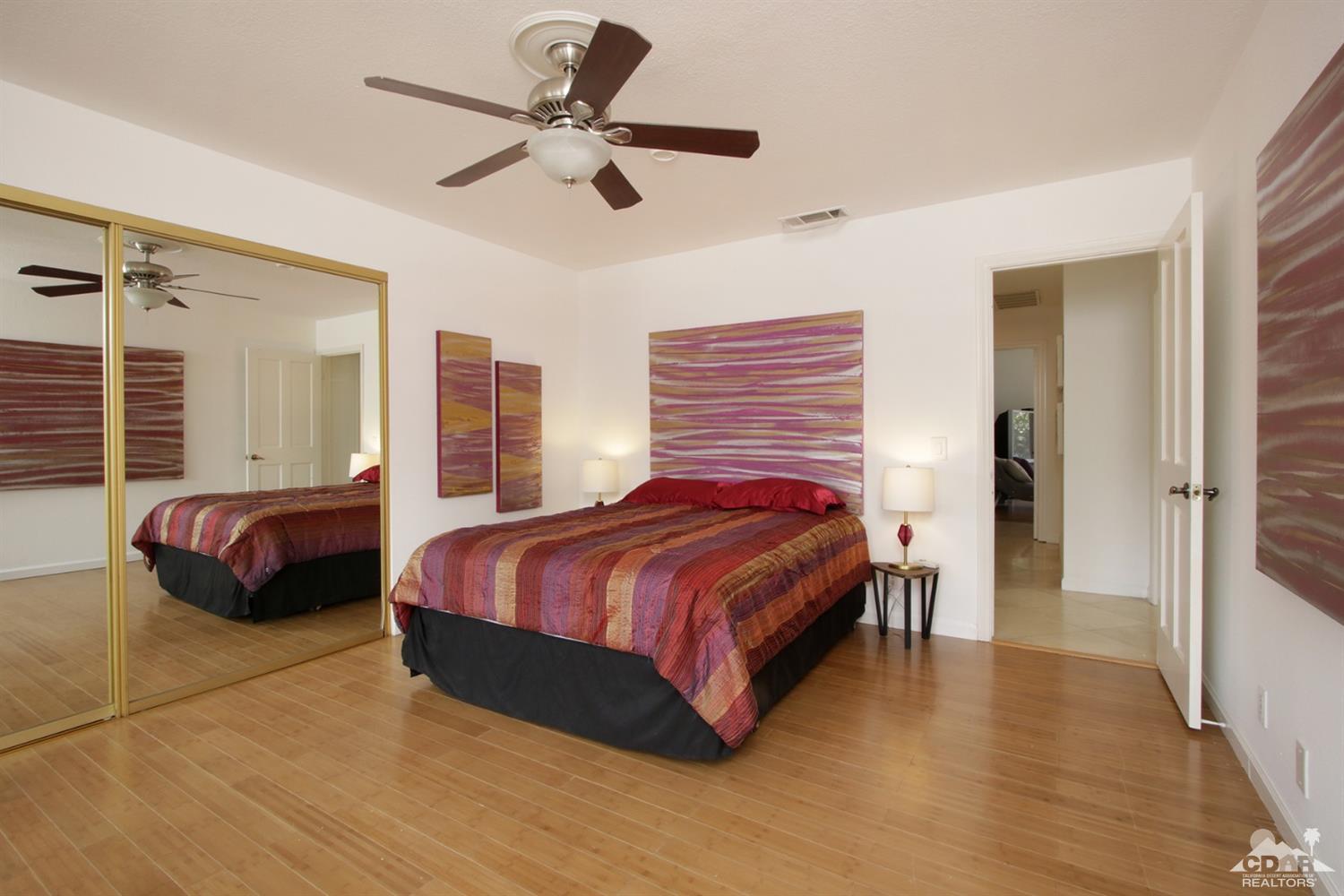75570 Fairway Drive Indian Wells, CA 92210 - Photo 19 of 38 a bedroom with a bed and a chandelier