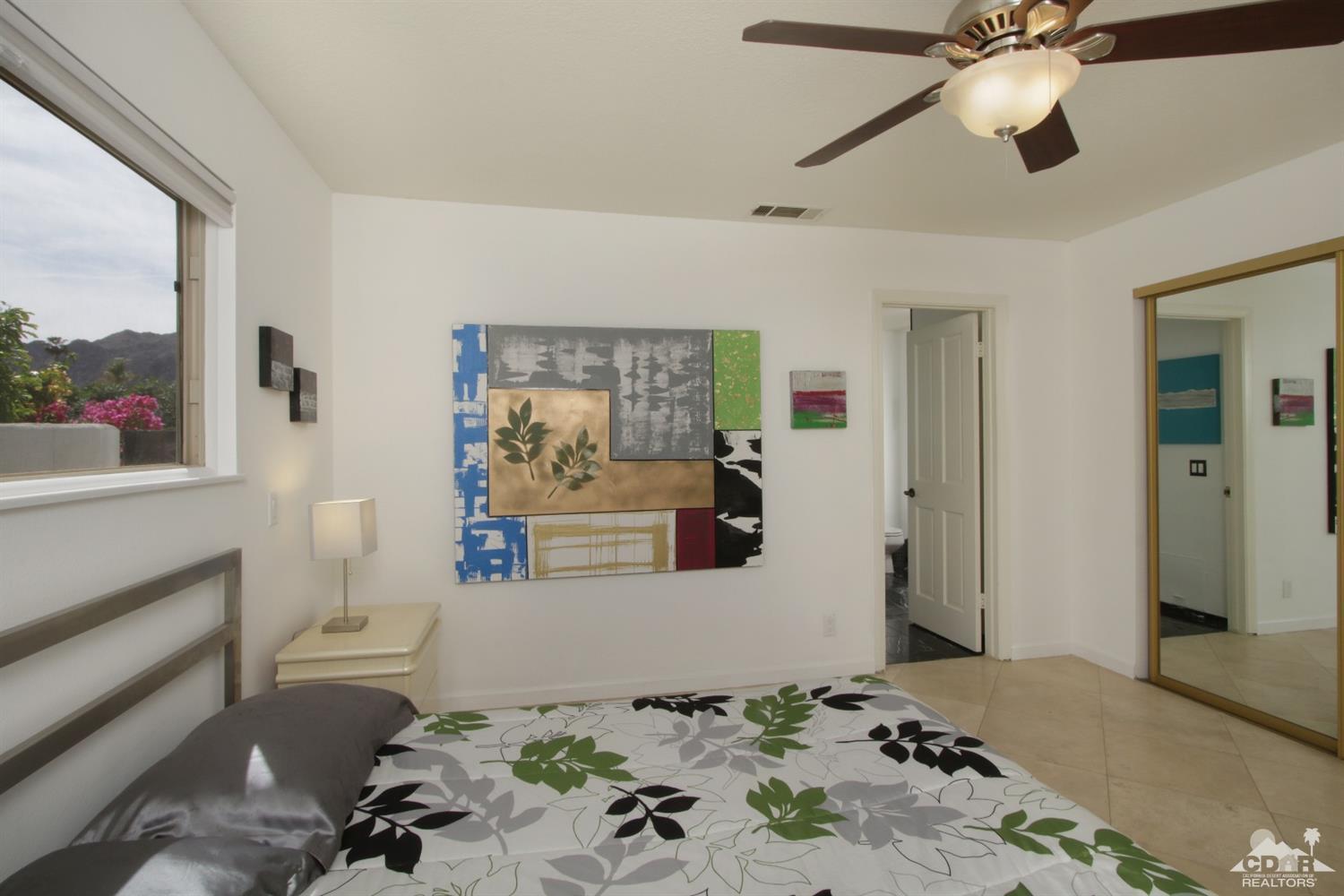 75570 Fairway Drive Indian Wells, CA 92210 - Photo 23 of 38 a bedroom with a bed and a chandelier